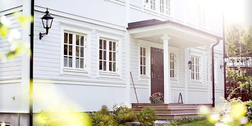 Flott, hvitt hus med en lekker ytterdør fra Dør & Vindu
